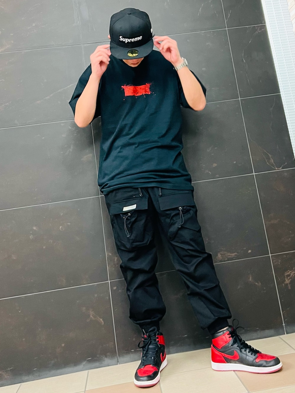 レッド系のスニーカー、ブラック系のTシャツ/カットソー、ブラック系のカーゴパンツを着用したメンズの夏コーディネートの3枚目の写真