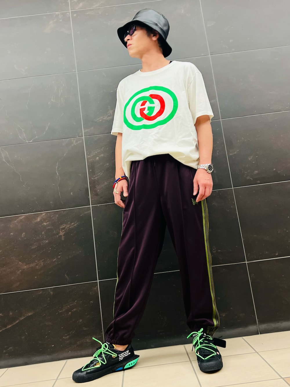 ブラウン系のその他パンツ、ブラック系のスニーカー、ホワイト系のTシャツ/カットソーを着用したメンズの春コーディネートの2枚目の写真