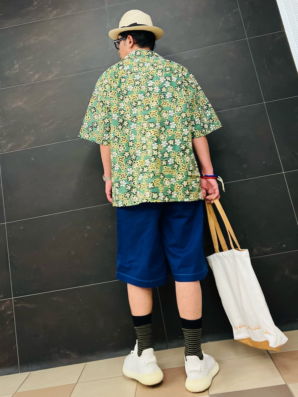 ベージュ系のトートバッグ、ホワイト系のスニーカー、グリーン系のシャツ/ブラウスを着用したメンズの夏コーディネートの4枚目の写真