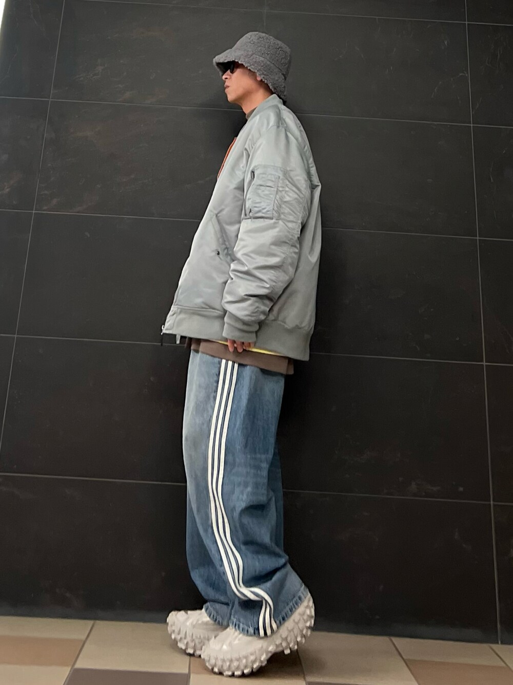 グレー系のMA-1、イエロー系のスウェット、ブラウン系のTシャツ/カットソーを着用したメンズの冬コーディネートの2枚目の写真