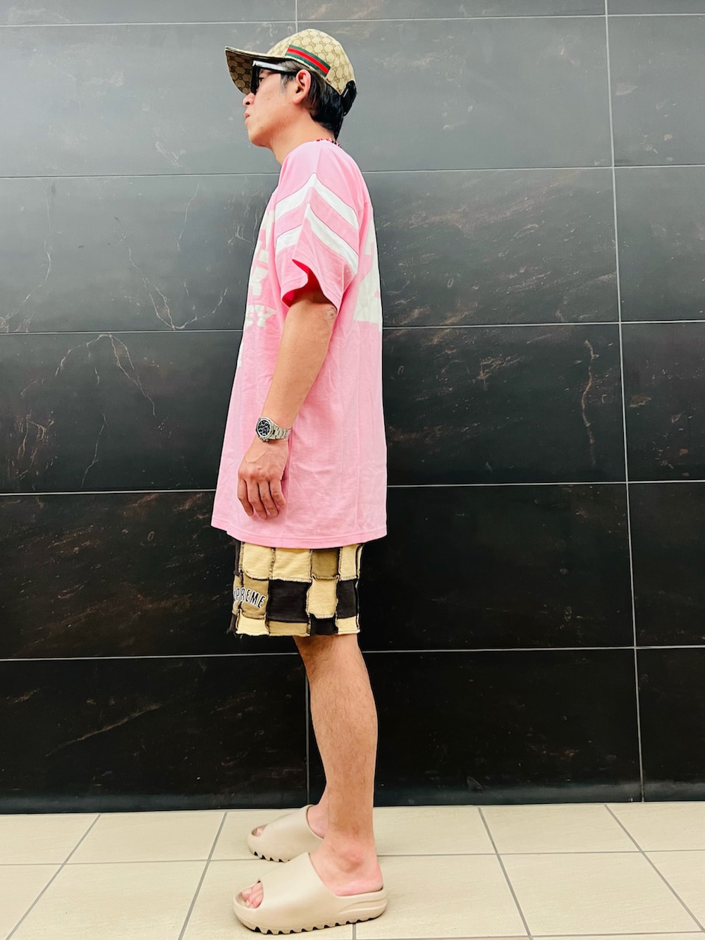 ピンク系のTシャツ/カットソー、ブラウン系のスウェットパンツ、ベージュ系のスニーカーを着用したメンズの夏コーディネートの3枚目の写真