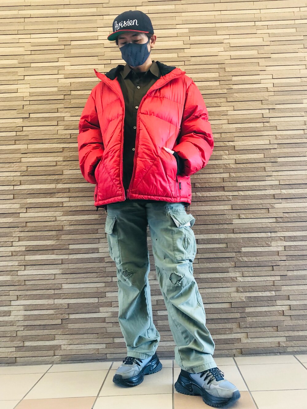 グレー系のスニーカー、グリーン系のカーゴパンツ、レッド系のダウンジャケット/コートを着用したメンズの冬コーディネートの3枚目の写真