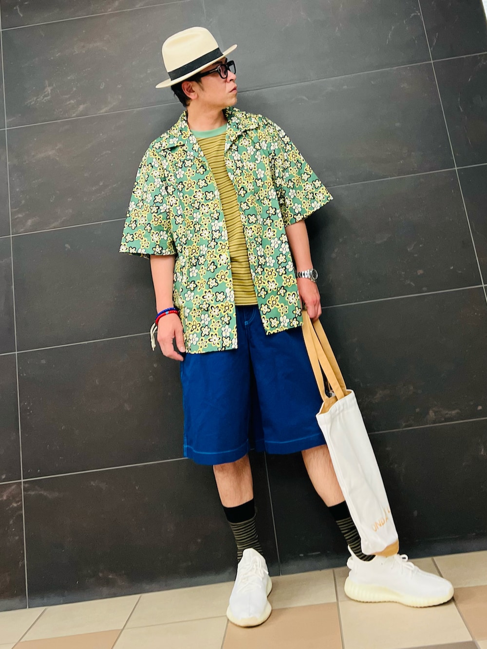 ベージュ系のトートバッグ、ホワイト系のスニーカー、グリーン系のシャツ/ブラウスを着用したメンズの夏コーディネートの3枚目の写真