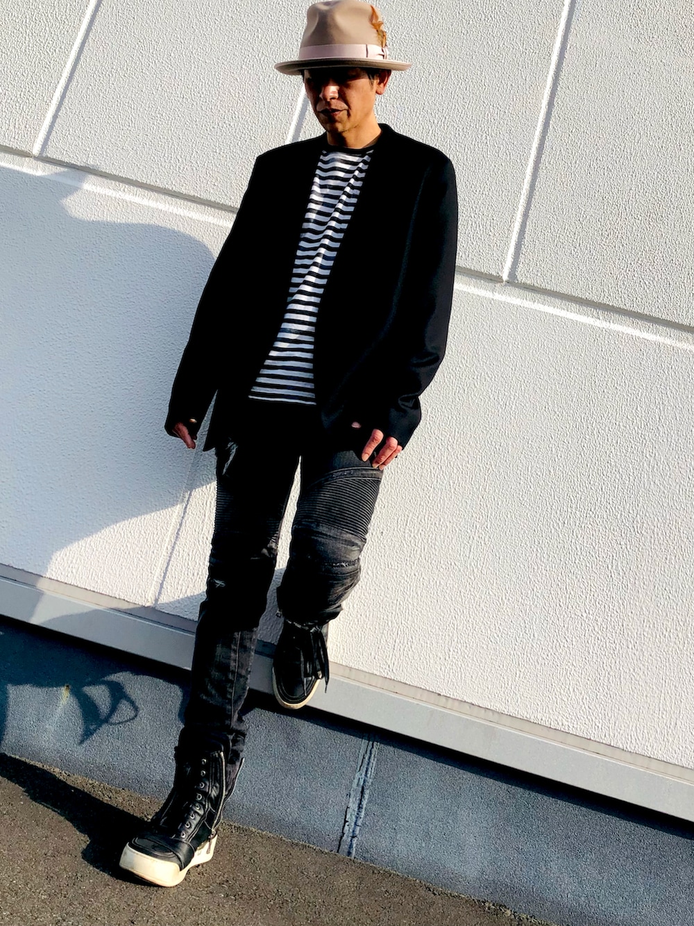 ブラック系のノーカラーコート、その他のTシャツ/カットソー、ブラック系のデニムパンツを着用したメンズの秋コーディネートの4枚目の写真