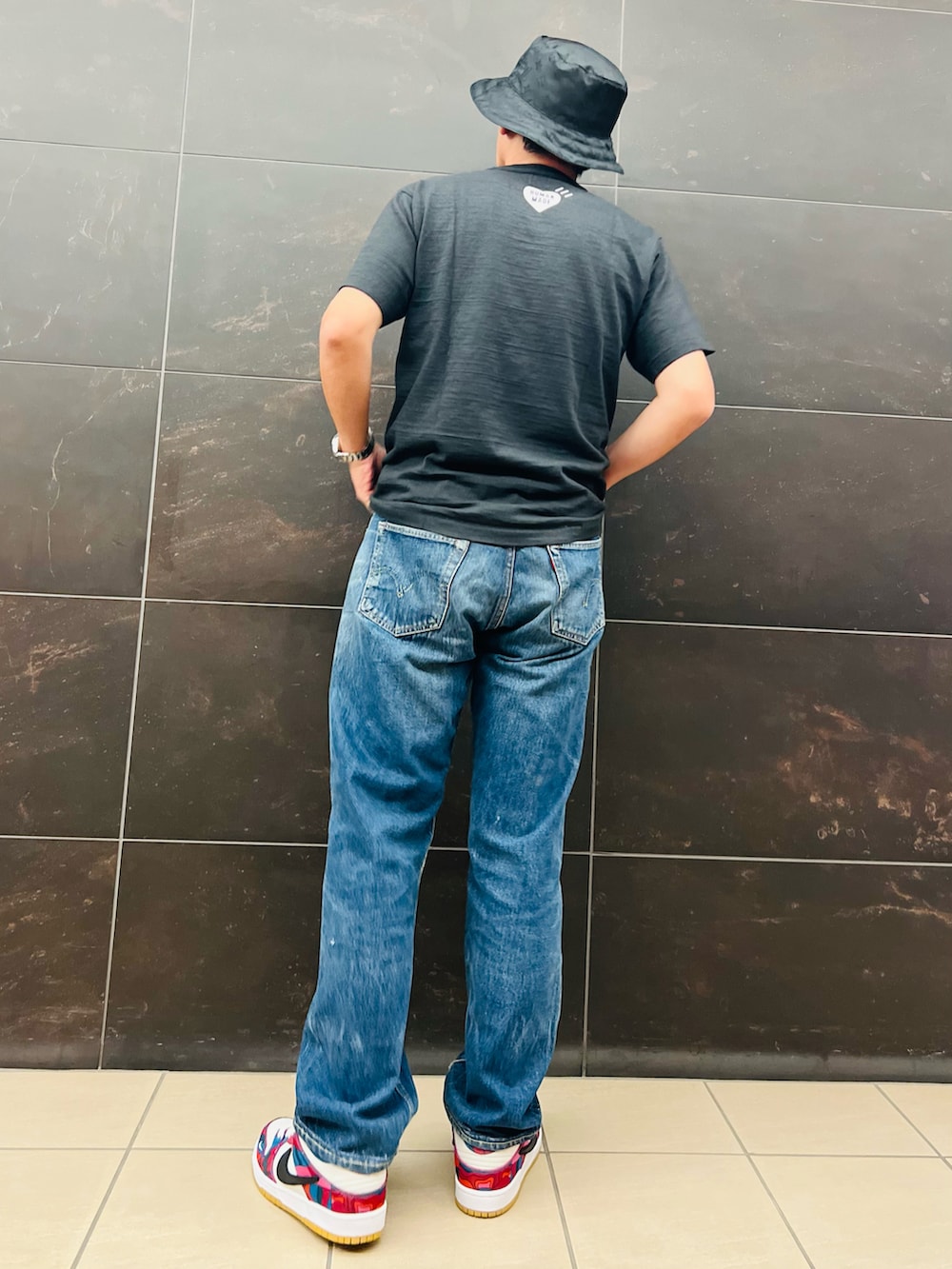ブラック系のTシャツ/カットソー、ブルー系のデニムパンツ、その他のスニーカーを着用したメンズの秋コーディネートの3枚目の写真