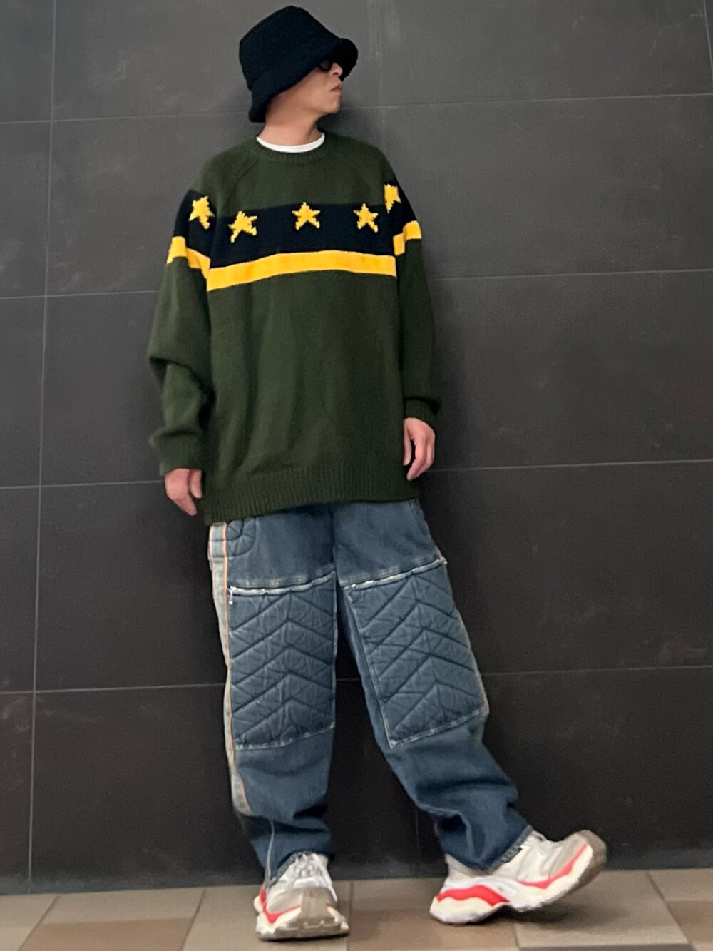 グリーン系のニット/セーター、ホワイト系のTシャツ/カットソー、ブルー系のデニムパンツを着用したメンズの春コーディネートの4枚目の写真