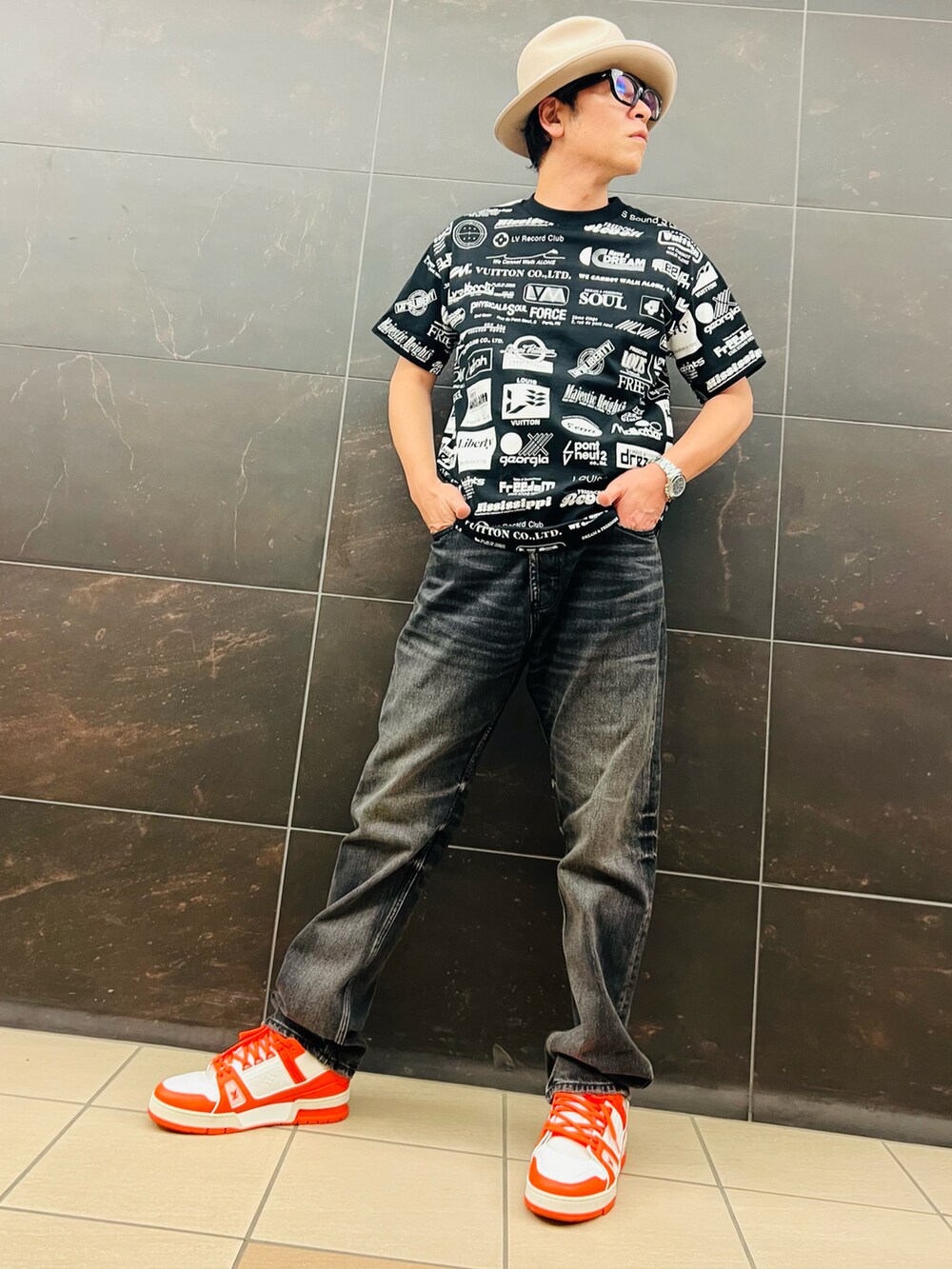 ブラック系のTシャツ/カットソー、ブラック系のデニムパンツ、オレンジ系のスニーカーを着用したメンズの夏コーディネートの4枚目の写真