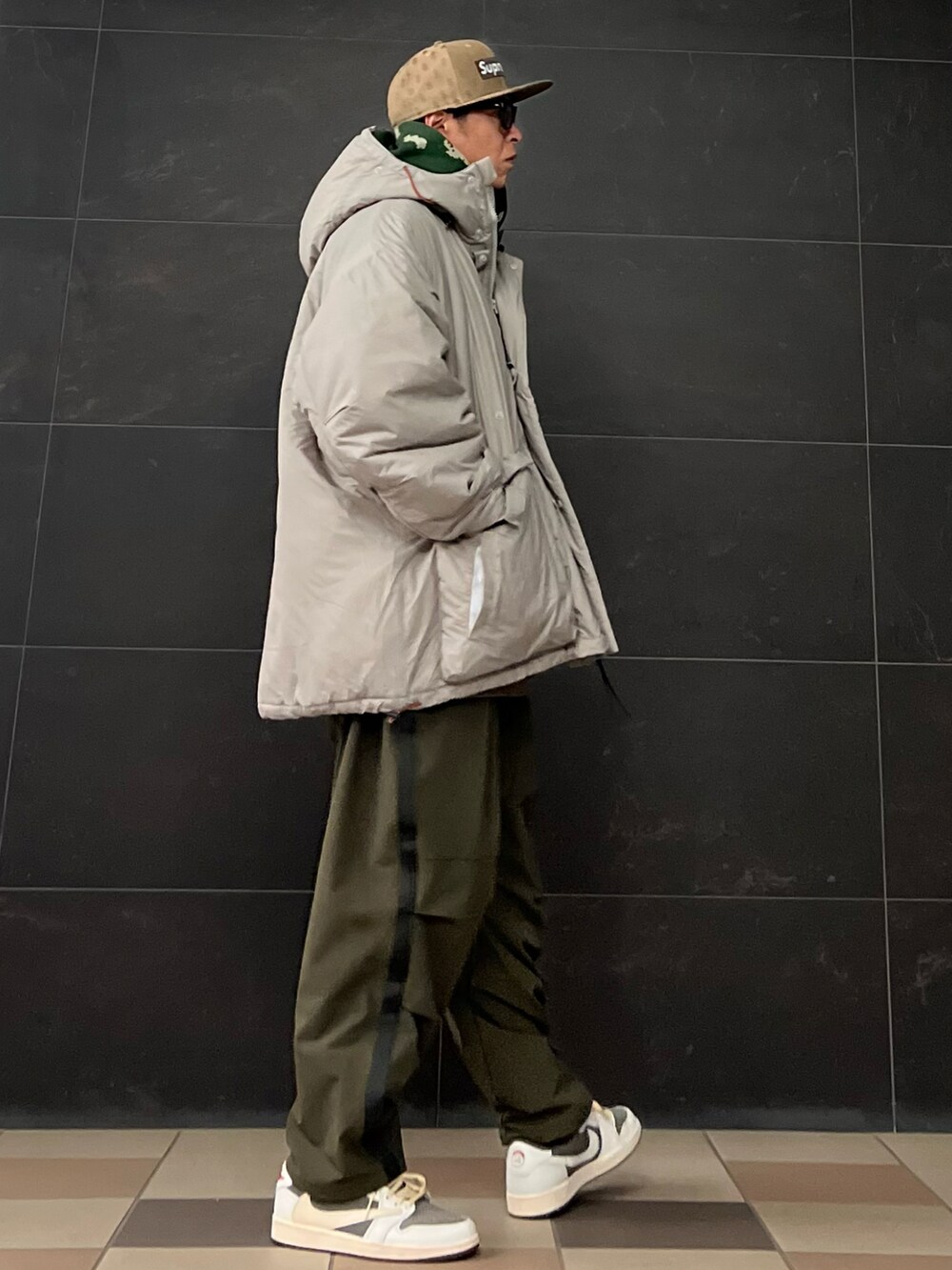 グリーン系のカーゴパンツ、シルバー系のダウンジャケット/コート、グレー系のスニーカーを着用したメンズの冬コーディネートの3枚目の写真