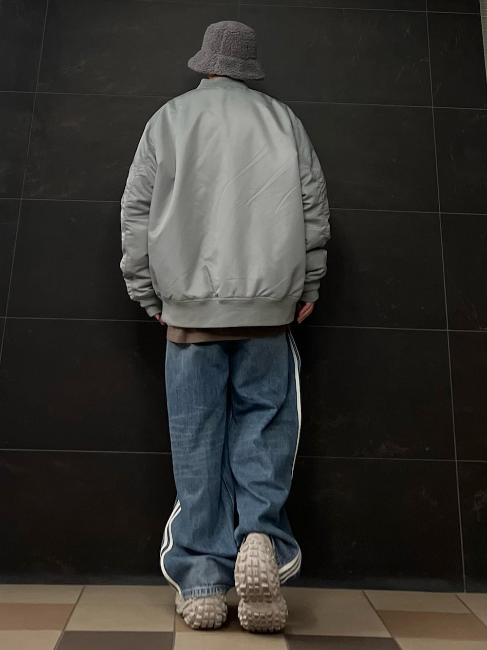 グレー系のMA-1、イエロー系のスウェット、ブラウン系のTシャツ/カットソーを着用したメンズの冬コーディネートの3枚目の写真