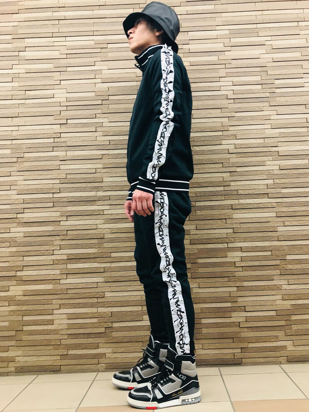 ブラック系のスニーカー、ブラック系のジャージ、ブラック系のその他パンツを着用したメンズの冬コーディネートの2枚目の写真