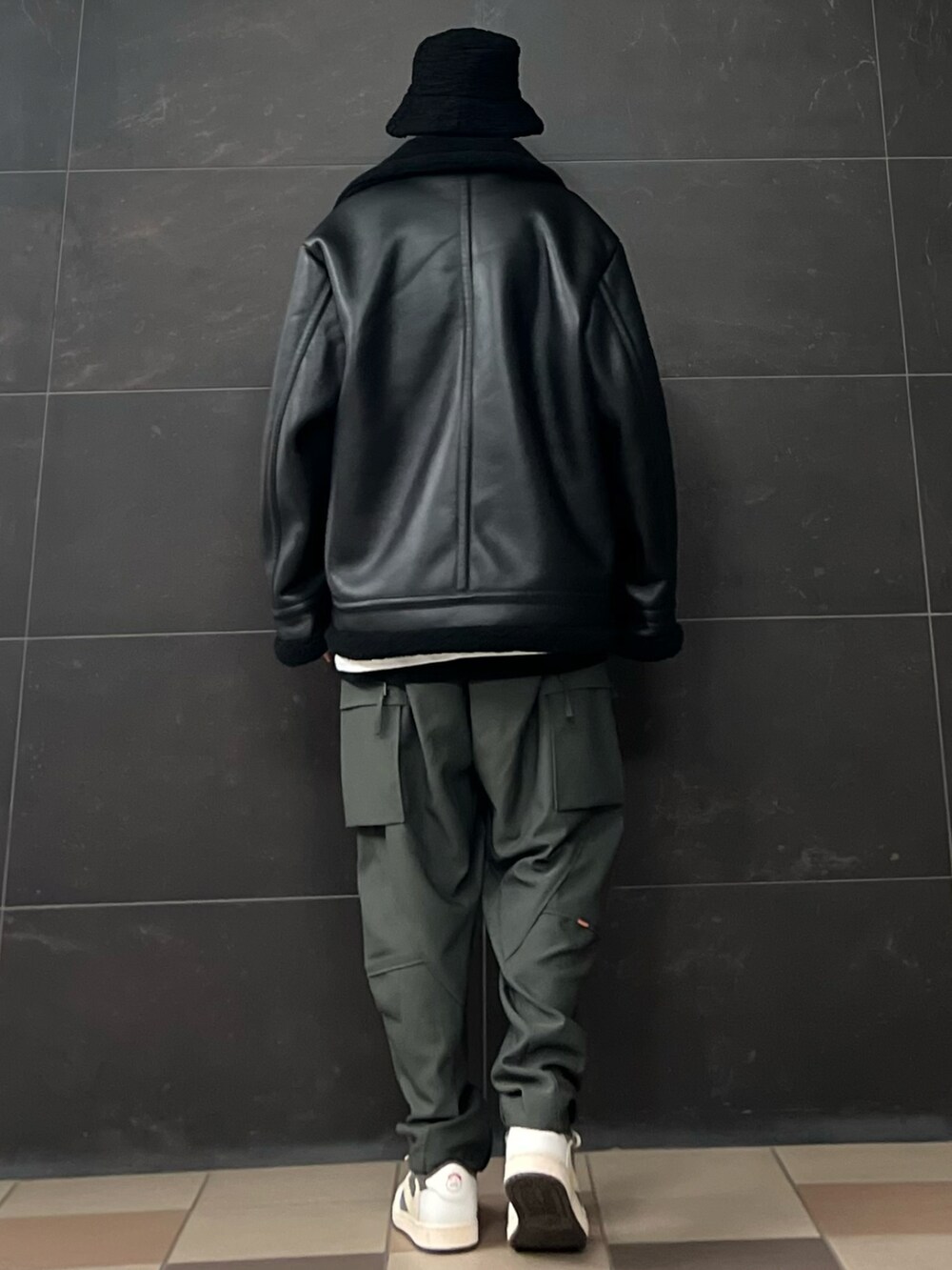 グレー系のスラックス、ホワイト系のTシャツ/カットソー、ブラック系のTシャツ/カットソーを着用したメンズの冬コーディネートの3枚目の写真