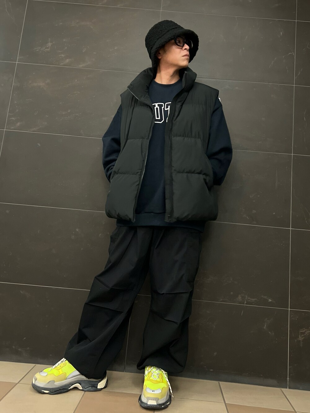 ブルー系のスウェット、ブラック系のカーゴパンツ、ブラック系のダウンベストを着用したメンズの冬コーディネートの2枚目の写真