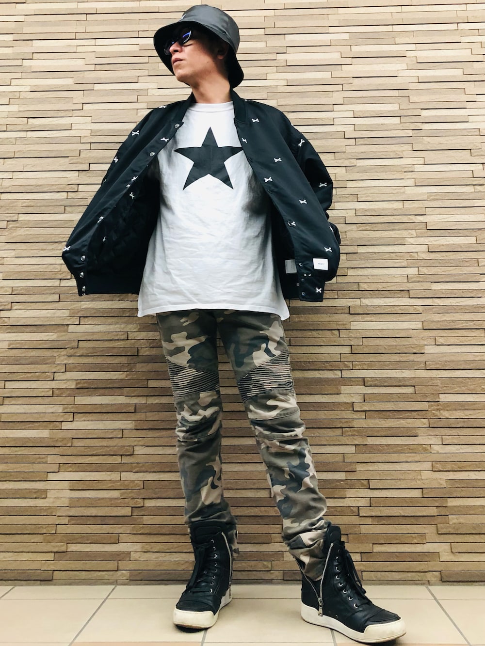 ブラック系のブルゾン、グリーン系のその他パンツ、ブラック系のスニーカーを着用したメンズの春コーディネートの3枚目の写真