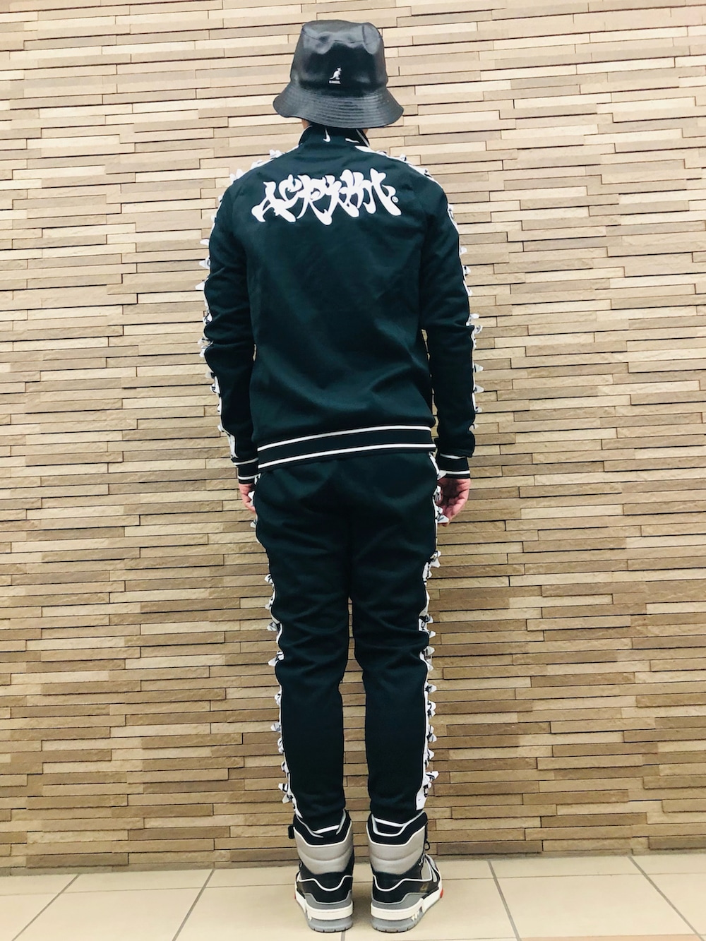 ブラック系のスニーカー、ブラック系のジャージ、ブラック系のその他パンツを着用したメンズの冬コーディネートの3枚目の写真