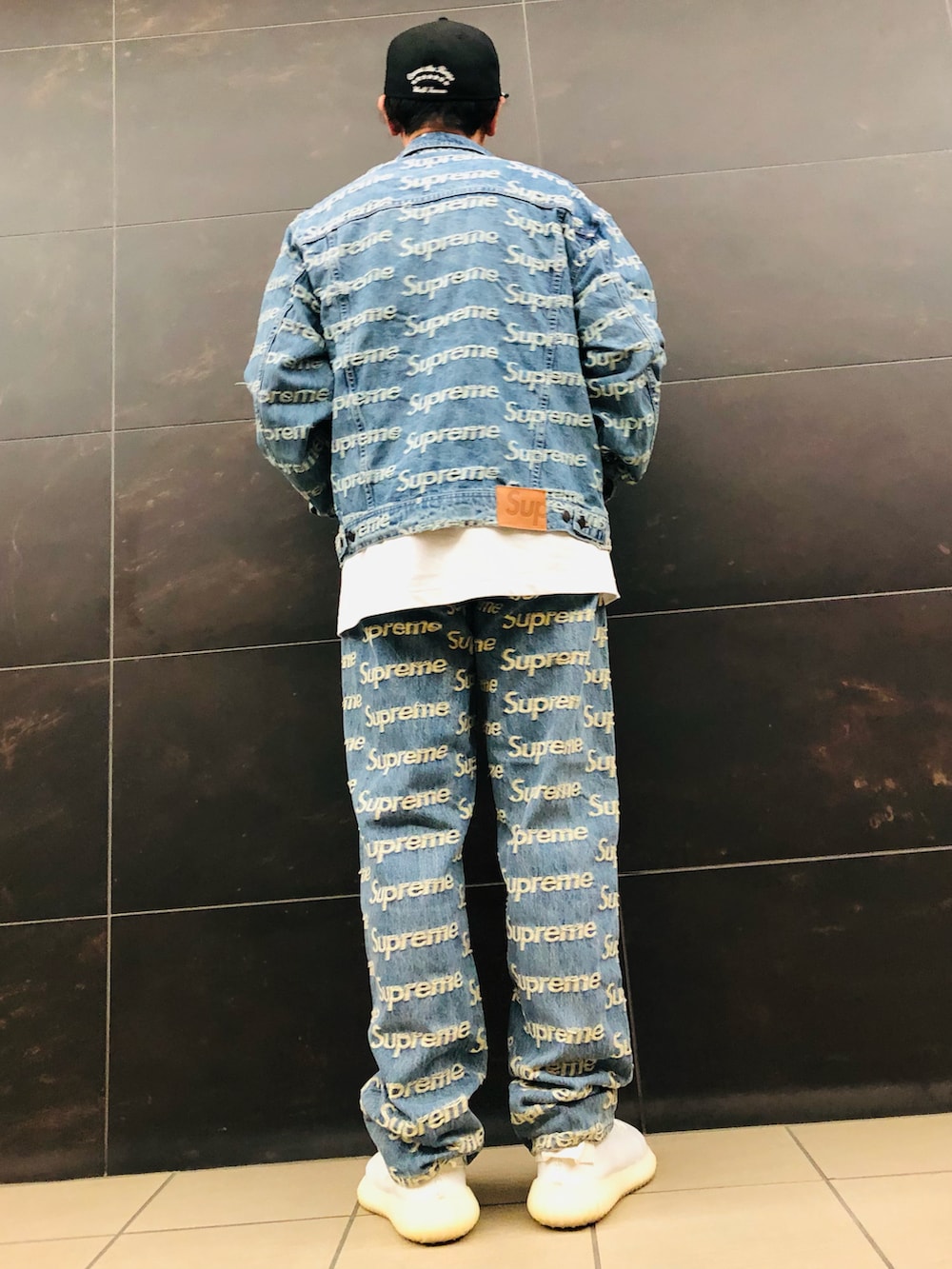 ブルー系のデニムパンツ、ブルー系のデニムジャケット、ホワイト系のスニーカーを着用したメンズの春コーディネートの2枚目の写真