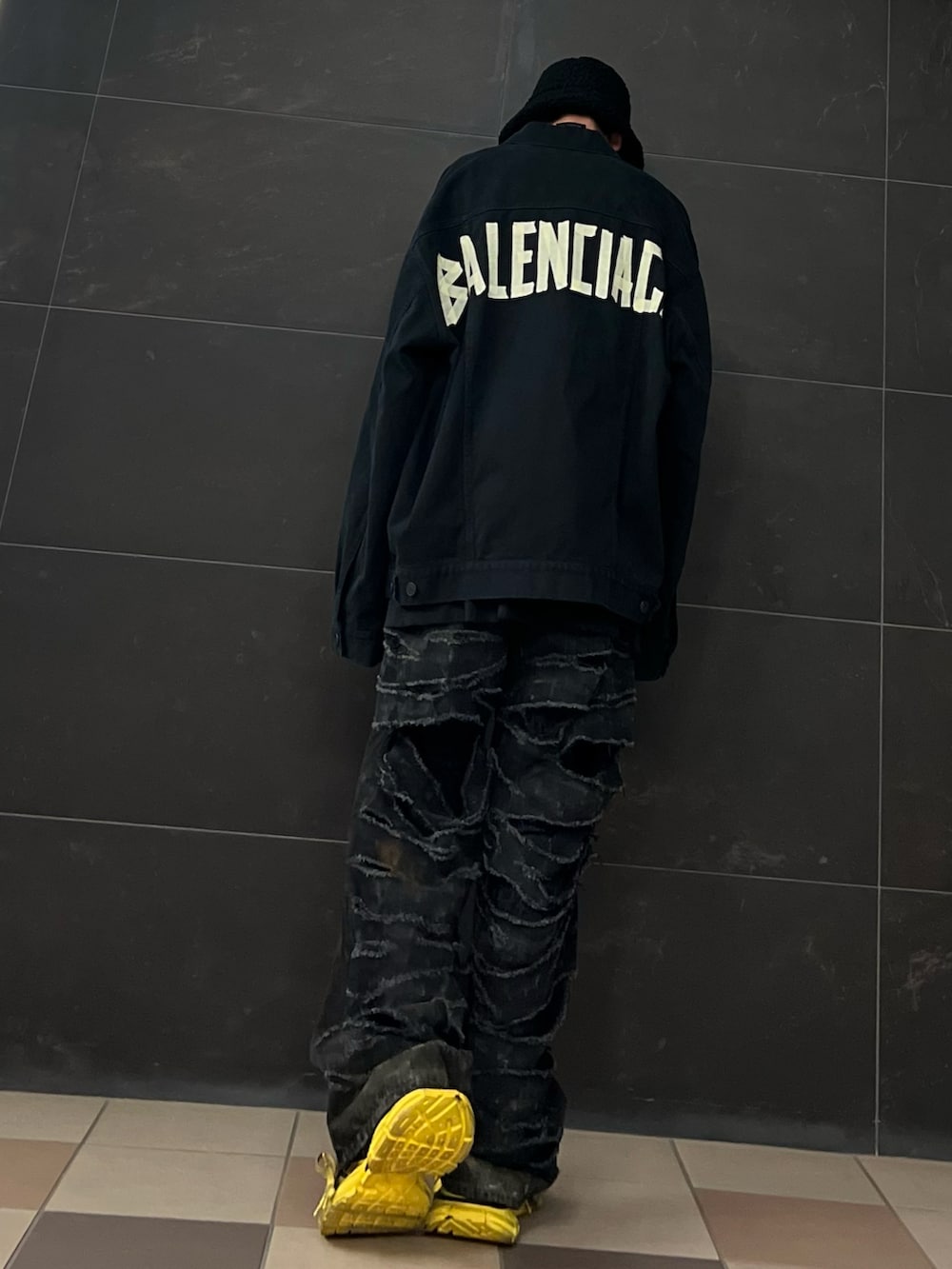 ブラック系のデニムパンツ、イエロー系のスニーカー、ブラック系のデニムジャケットを着用したメンズの夏コーディネートの4枚目の写真