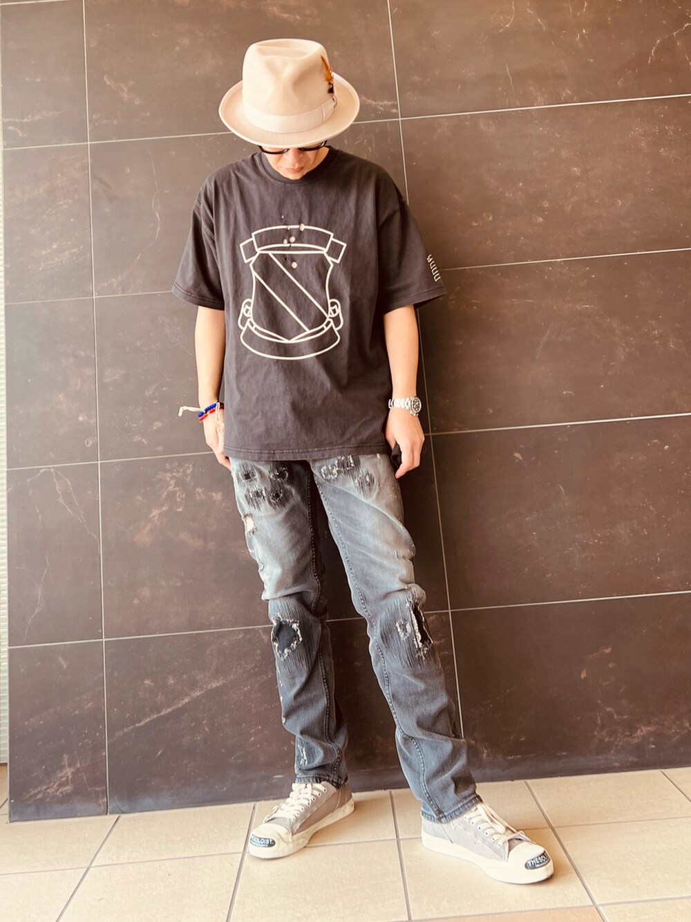 ブラック系のデニムパンツ、ブラック系のTシャツ/カットソー、グレー系のスニーカーを着用したメンズの春コーディネートの2枚目の写真