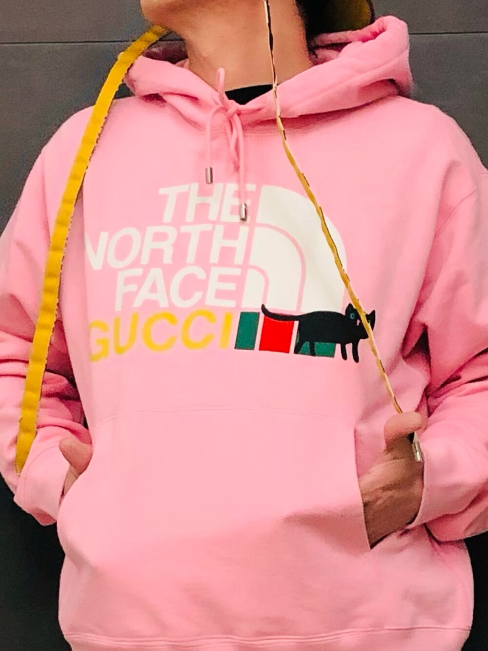 ピンク系のパーカー、ピンク系のパーカー、イエロー系のスニーカーを着用したメンズの春コーディネートの3枚目の写真