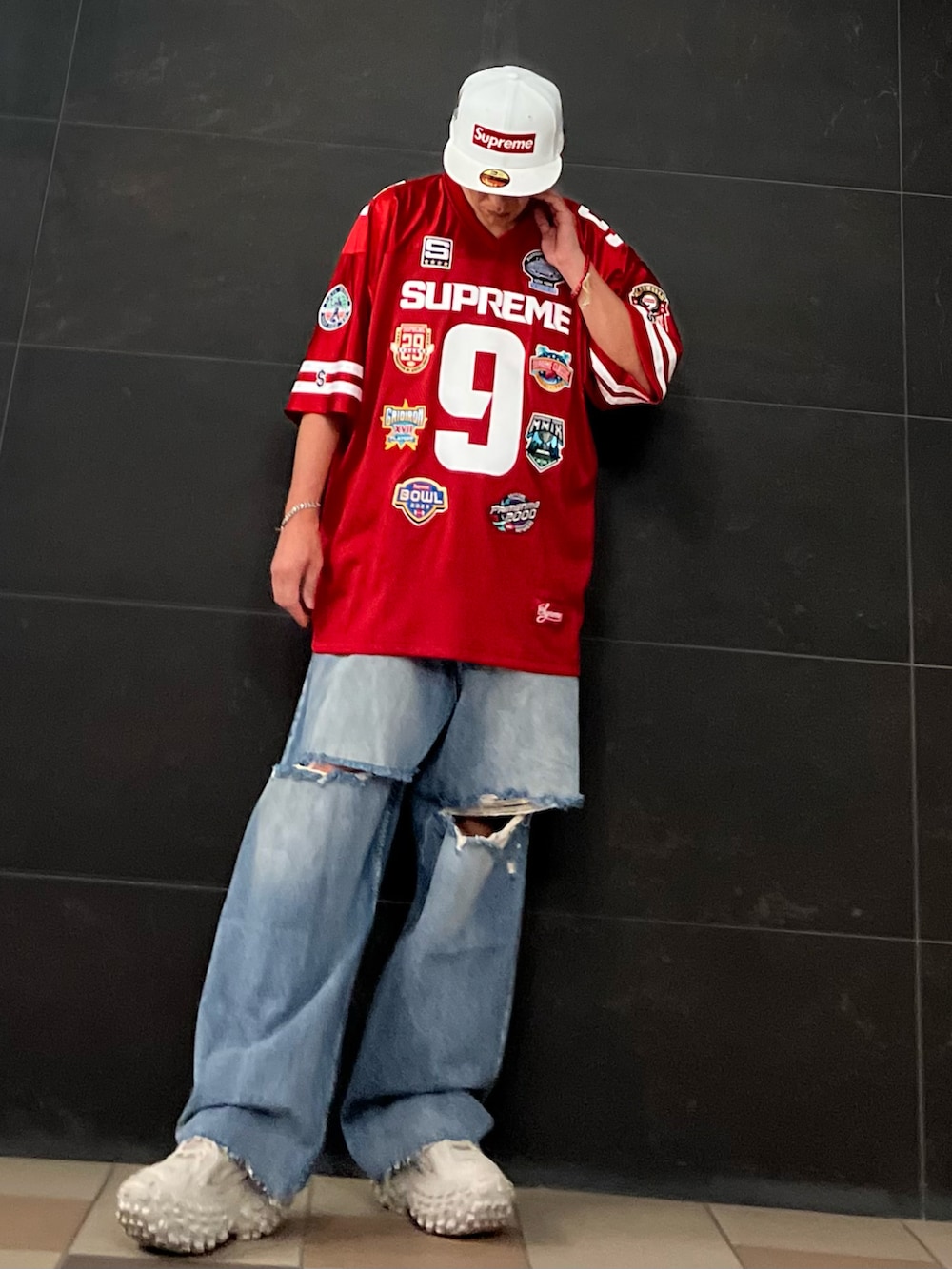 レッド系のシャツ/ブラウス、ブルー系のデニムパンツ、ベージュ系のスニーカーを着用したメンズの秋コーディネートの3枚目の写真