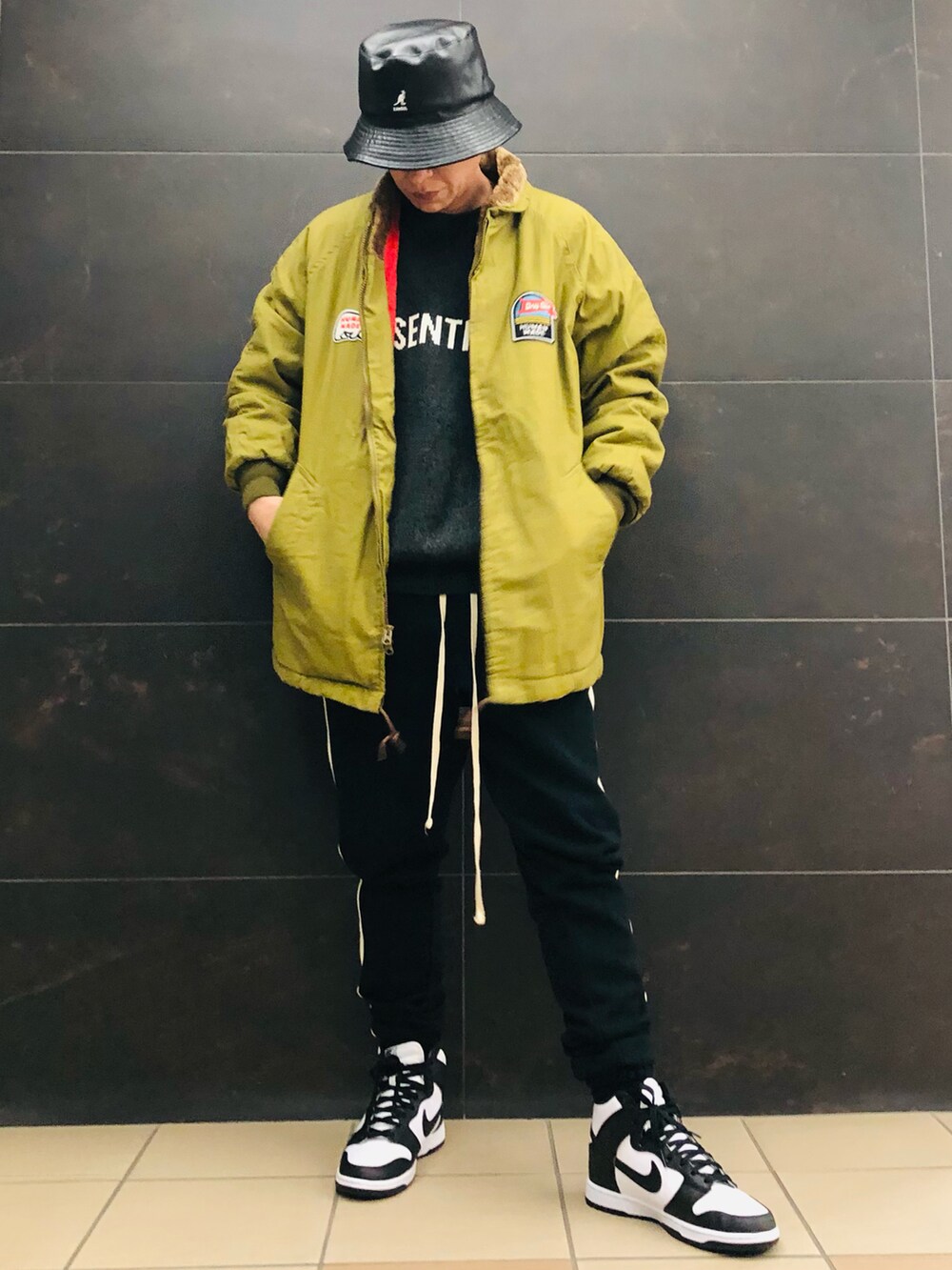 ブラック系のスニーカー、ブラック系のスウェットパンツ、ブラック系のニット/セーターを着用したメンズの春コーディネートの2枚目の写真