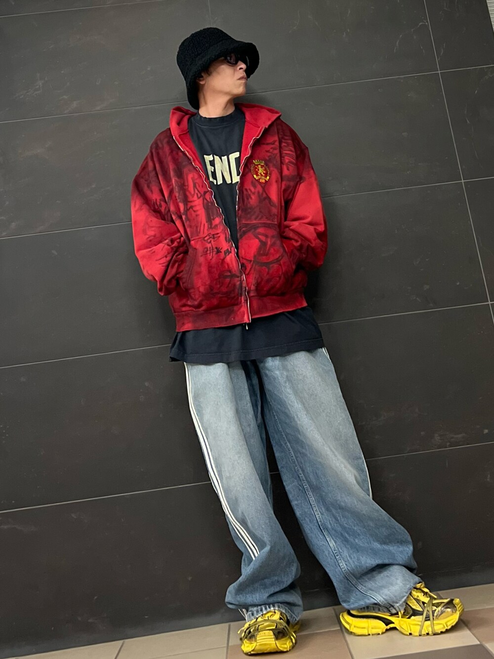 ブルー系のデニムパンツ、イエロー系のスニーカー、ブラック系のTシャツ/カットソーを着用したメンズの春コーディネートの5枚目の写真