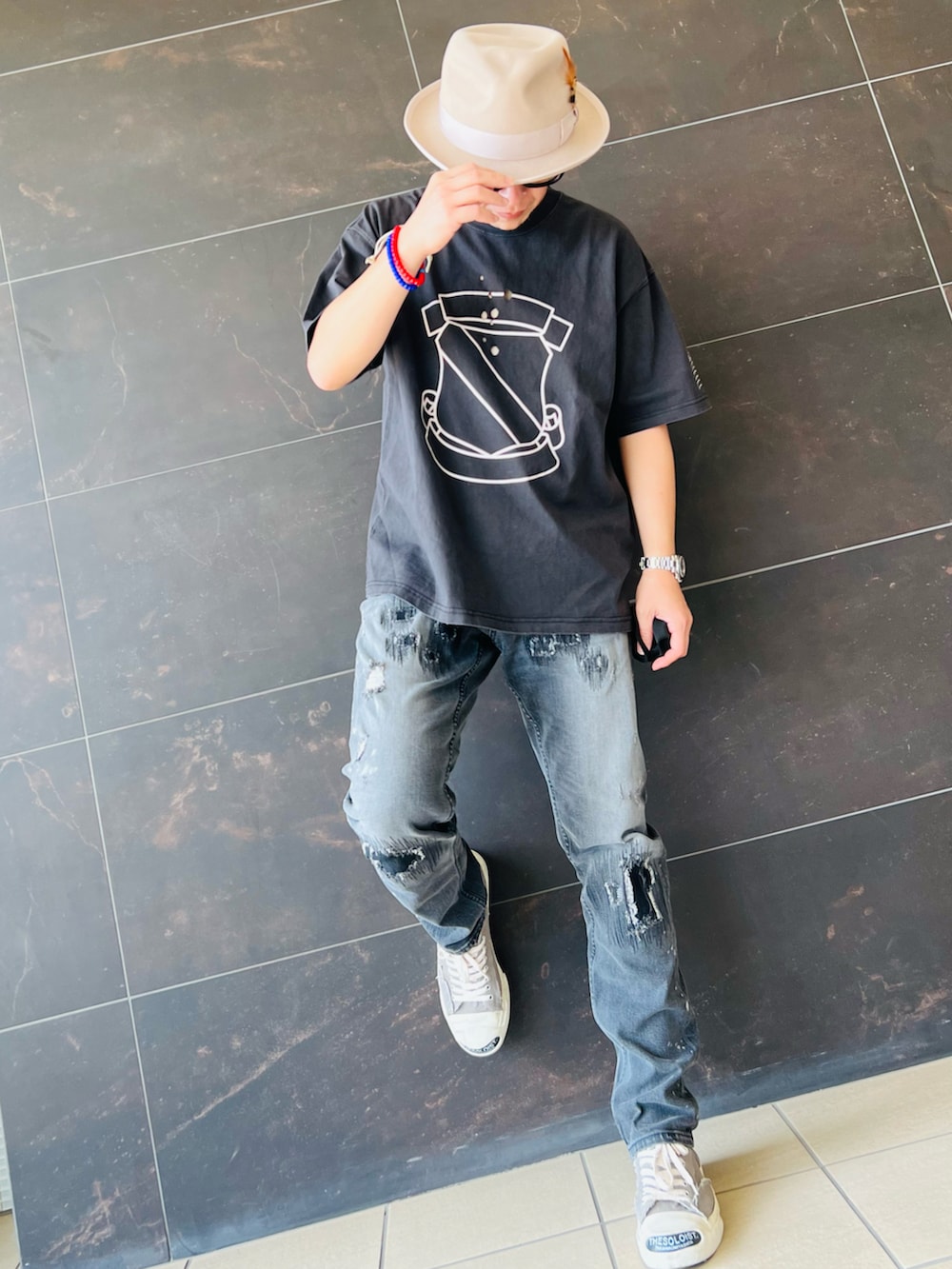 ブラック系のデニムパンツ、ブラック系のTシャツ/カットソー、グレー系のスニーカーを着用したメンズの春コーディネートの3枚目の写真