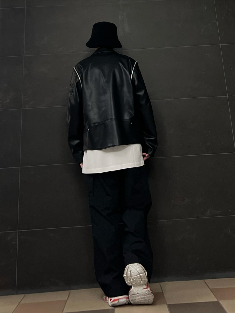 ブラック系のライダースジャケット、ホワイト系のTシャツ/カットソー、ブラック系のカーゴパンツを着用したメンズの春コーディネートの4枚目の写真