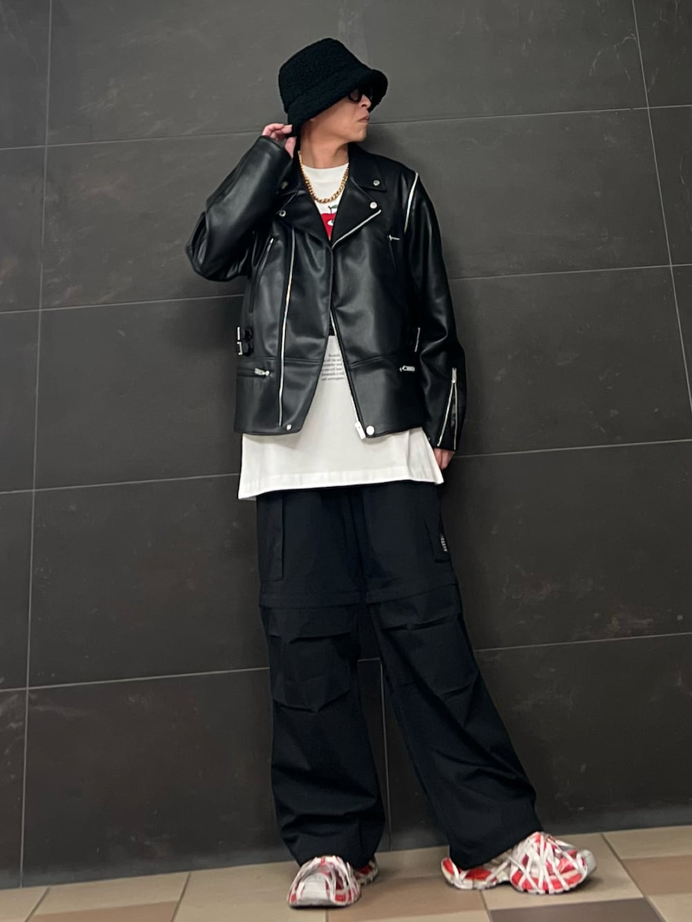 ブラック系のライダースジャケット、ホワイト系のTシャツ/カットソー、ブラック系のカーゴパンツを着用したメンズの春コーディネートの3枚目の写真