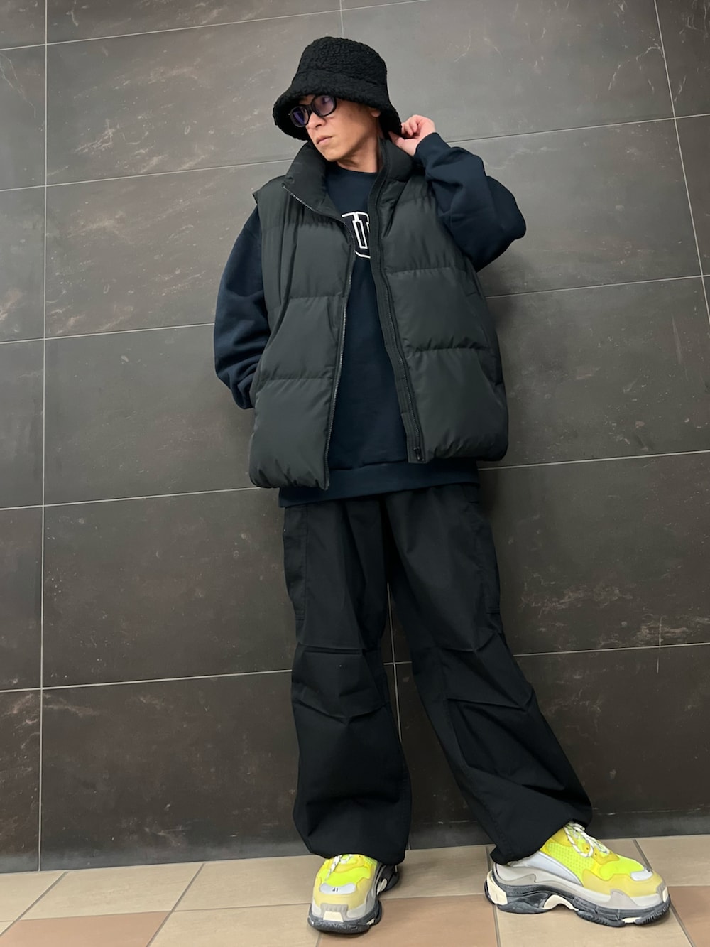 ブルー系のスウェット、ブラック系のカーゴパンツ、ブラック系のダウンベストを着用したメンズの冬コーディネートの4枚目の写真