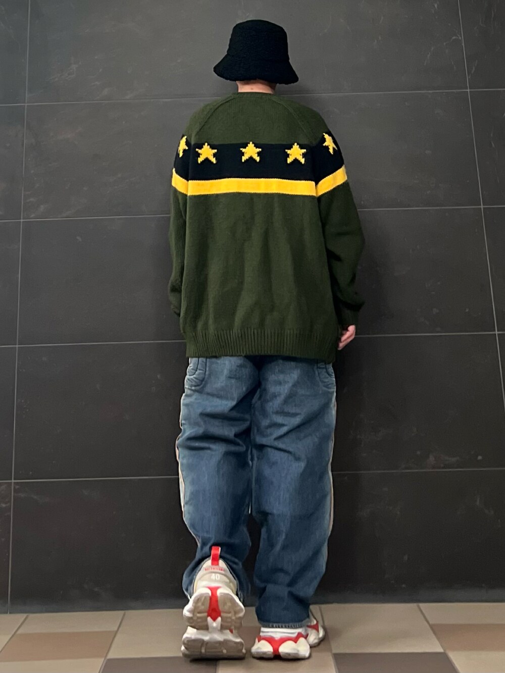 グリーン系のニット/セーター、ホワイト系のTシャツ/カットソー、ブルー系のデニムパンツを着用したメンズの春コーディネートの3枚目の写真