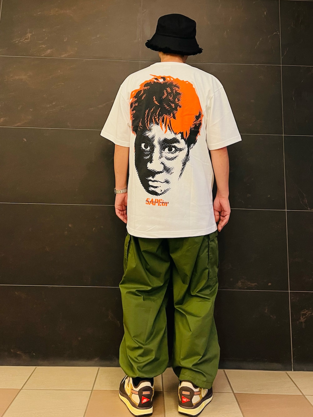 ブラウン系のスニーカー、ホワイト系のTシャツ/カットソー、グリーン系のカーゴパンツを着用したメンズの夏コーディネートの3枚目の写真