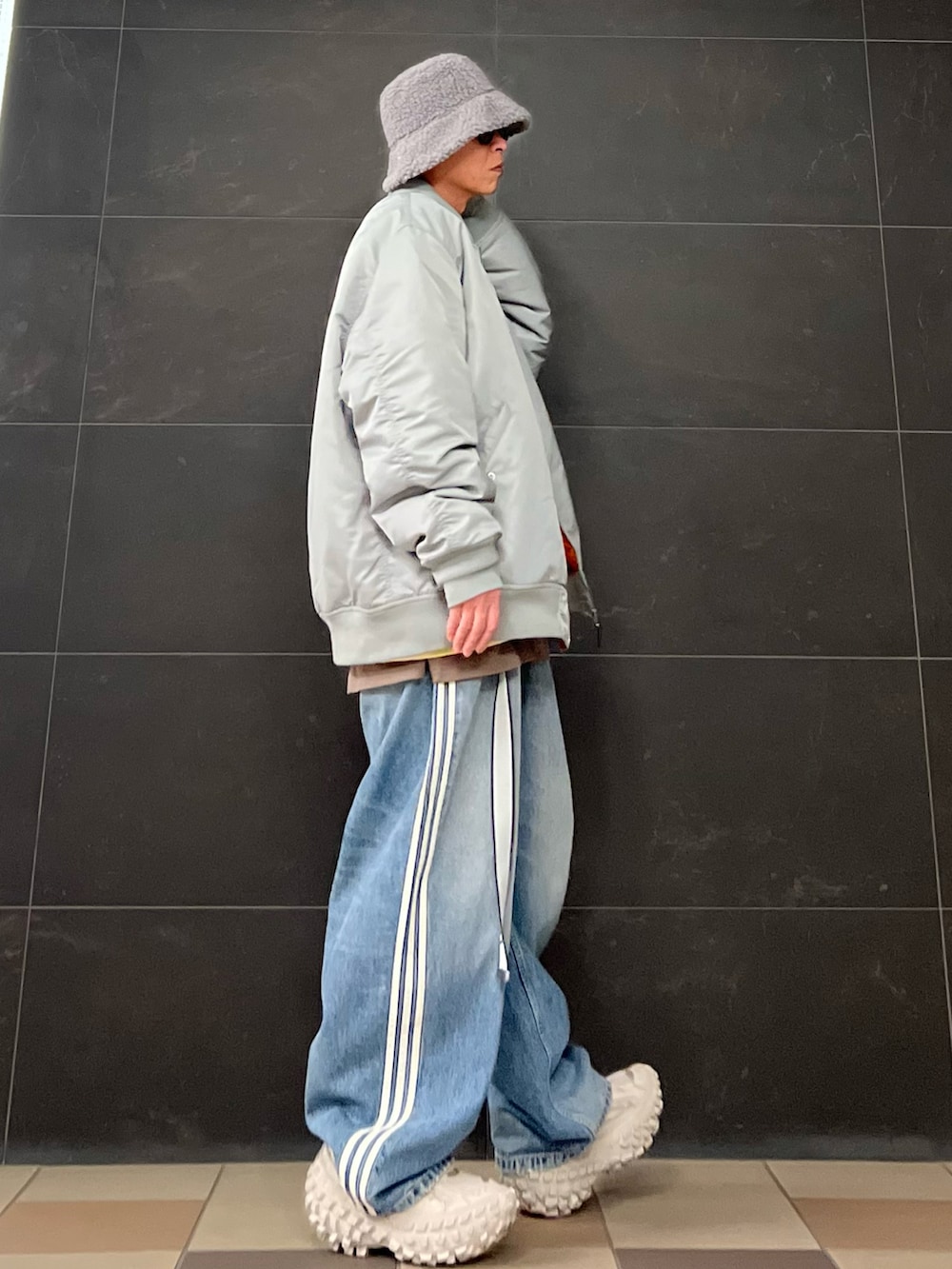 グレー系のMA-1、イエロー系のスウェット、ブラウン系のTシャツ/カットソーを着用したメンズの冬コーディネートの4枚目の写真