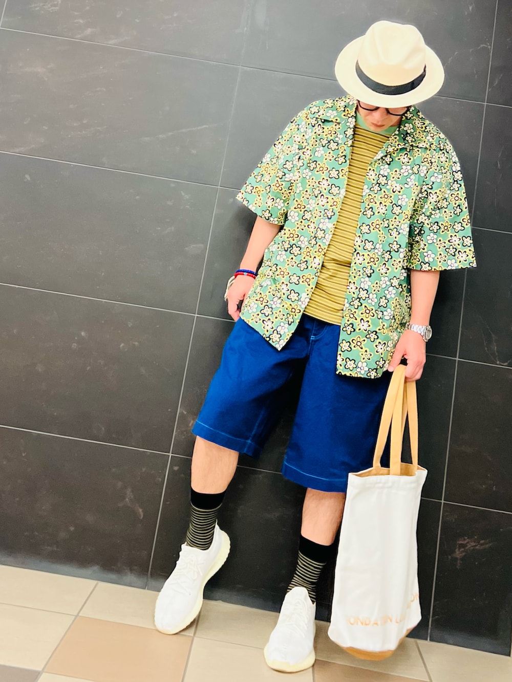 ベージュ系のトートバッグ、ホワイト系のスニーカー、グリーン系のシャツ/ブラウスを着用したメンズの夏コーディネートの2枚目の写真