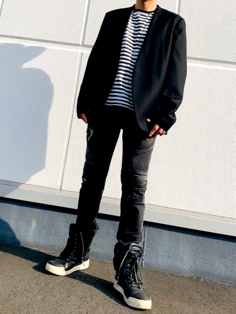 ブラック系のノーカラーコート、その他のTシャツ/カットソー、ブラック系のデニムパンツを着用したメンズの秋コーディネートの3枚目の写真