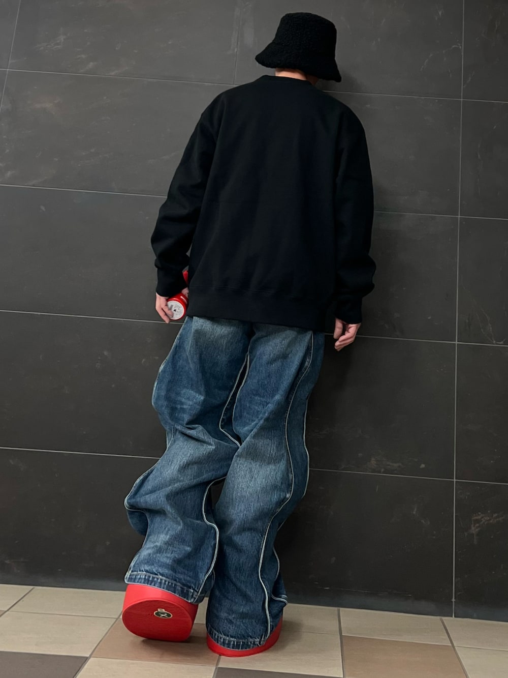 ブラック系のスウェット、ブルー系のデニムパンツ、レッド系のブーツを着用したメンズの夏コーディネートの4枚目の写真