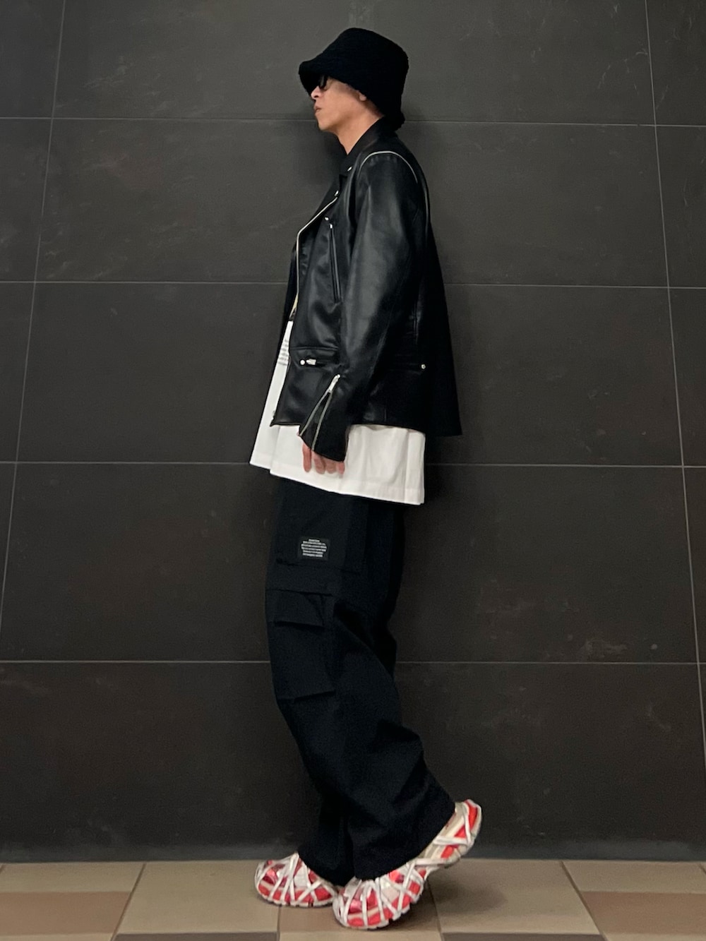 ブラック系のライダースジャケット、ホワイト系のTシャツ/カットソー、ブラック系のカーゴパンツを着用したメンズの春コーディネートの5枚目の写真