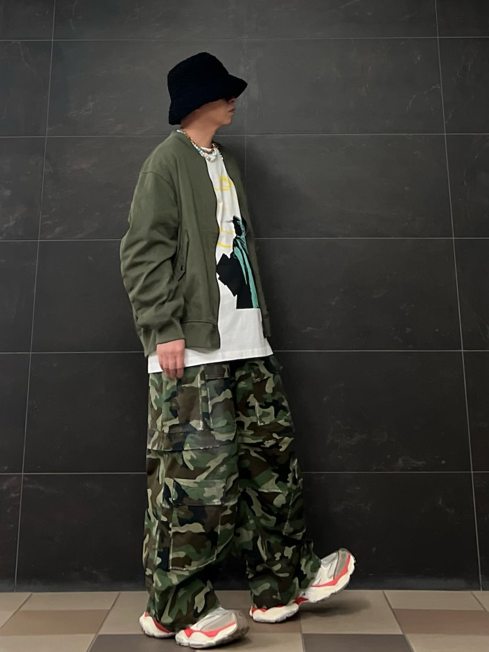 グリーン系のスウェット、ホワイト系のTシャツ/カットソー、グリーン系のカーゴパンツを着用したメンズの春コーディネートの3枚目の写真