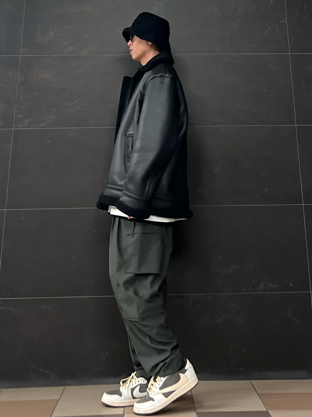 グレー系のスラックス、ホワイト系のTシャツ/カットソー、ブラック系のTシャツ/カットソーを着用したメンズの冬コーディネートの4枚目の写真