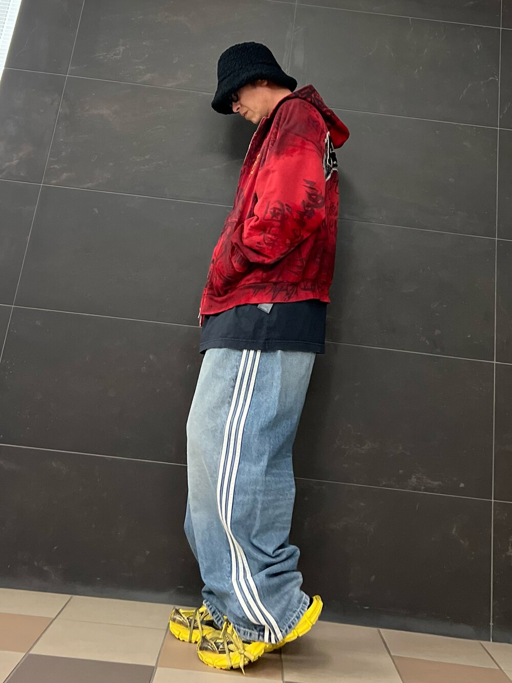 ブルー系のデニムパンツ、イエロー系のスニーカー、ブラック系のTシャツ/カットソーを着用したメンズの春コーディネートの3枚目の写真