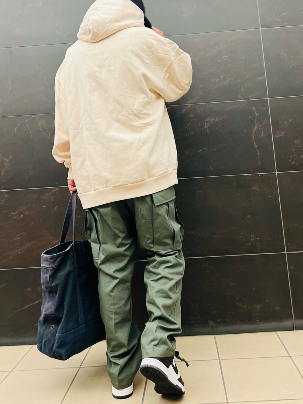 ベージュ系のパーカー、グリーン系のカーゴパンツ、ブラック系のスニーカーを着用したメンズの秋コーディネートの4枚目の写真