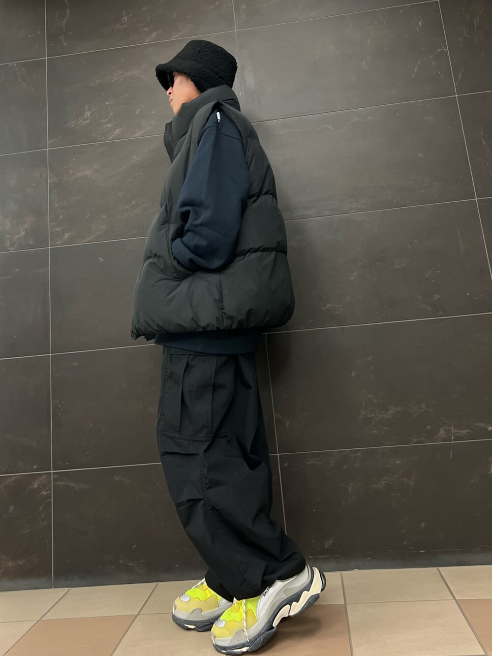 ブルー系のスウェット、ブラック系のカーゴパンツ、ブラック系のダウンベストを着用したメンズの冬コーディネートの3枚目の写真