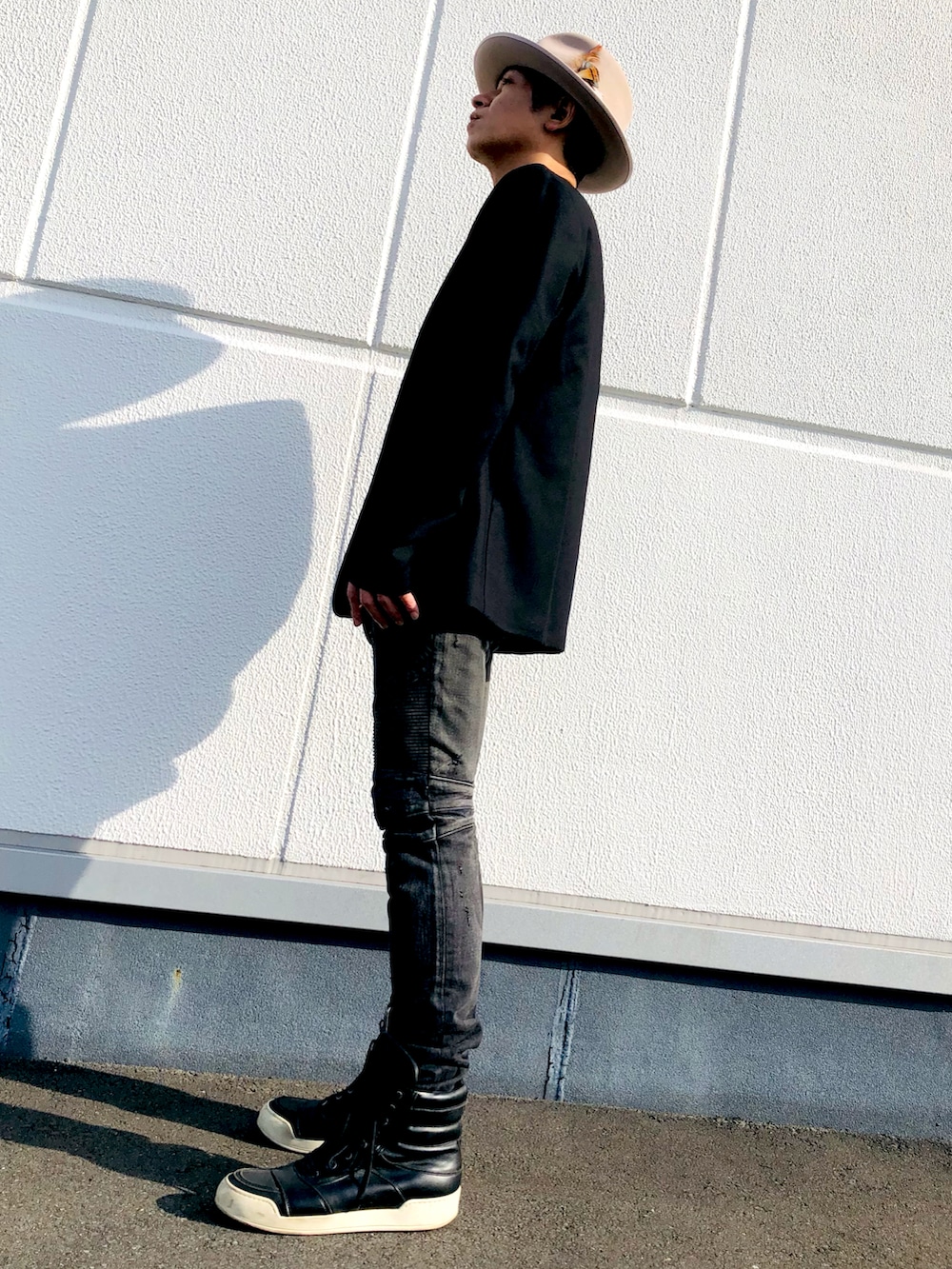 ブラック系のノーカラーコート、その他のTシャツ/カットソー、ブラック系のデニムパンツを着用したメンズの秋コーディネートの2枚目の写真