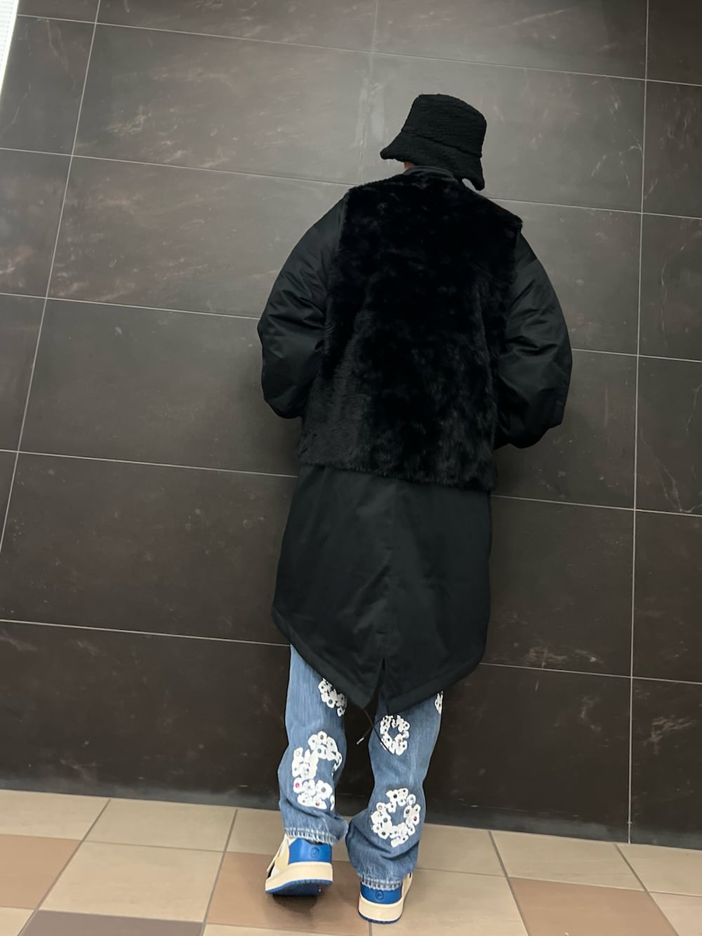 ブルー系のデニムパンツ、ブルー系のスニーカー、ブラック系のモッズコートを着用したメンズの冬コーディネートの3枚目の写真