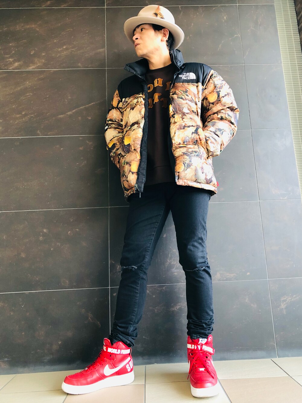 ベージュ系のダウンジャケット/コート、ブラウン系のスウェット、ブラック系のデニムパンツを着用したメンズの冬コーディネートの2枚目の写真