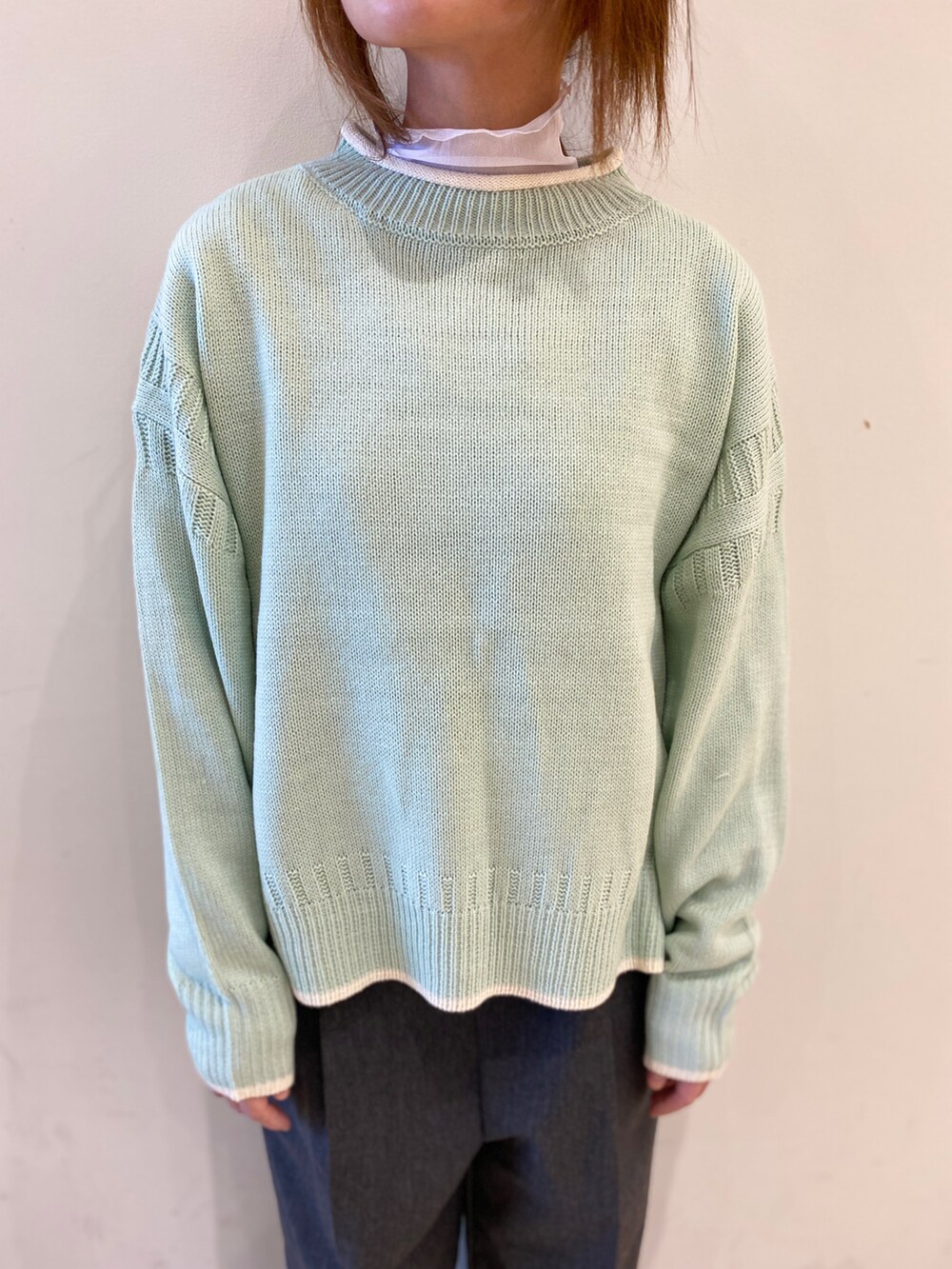 グリーン系のニット/セーター、ホワイト系のTシャツ/カットソー、ブラック系のその他パンツを着用したレディースの冬コーディネートの2枚目の写真