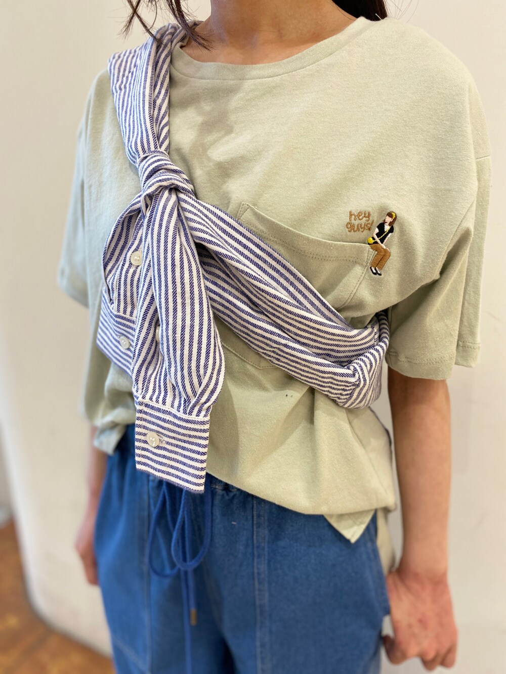 ブルー系のシャツ/ブラウス、グリーン系のTシャツ/カットソー、ブルー系のデニムパンツを着用したレディースの春コーディネートの2枚目の写真