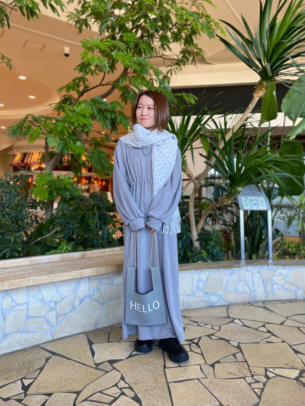 ブラック系のブルゾン、グレー系のワンピース、グレー系のハンドバッグを着用したレディースの冬コーディネートの2枚目の写真