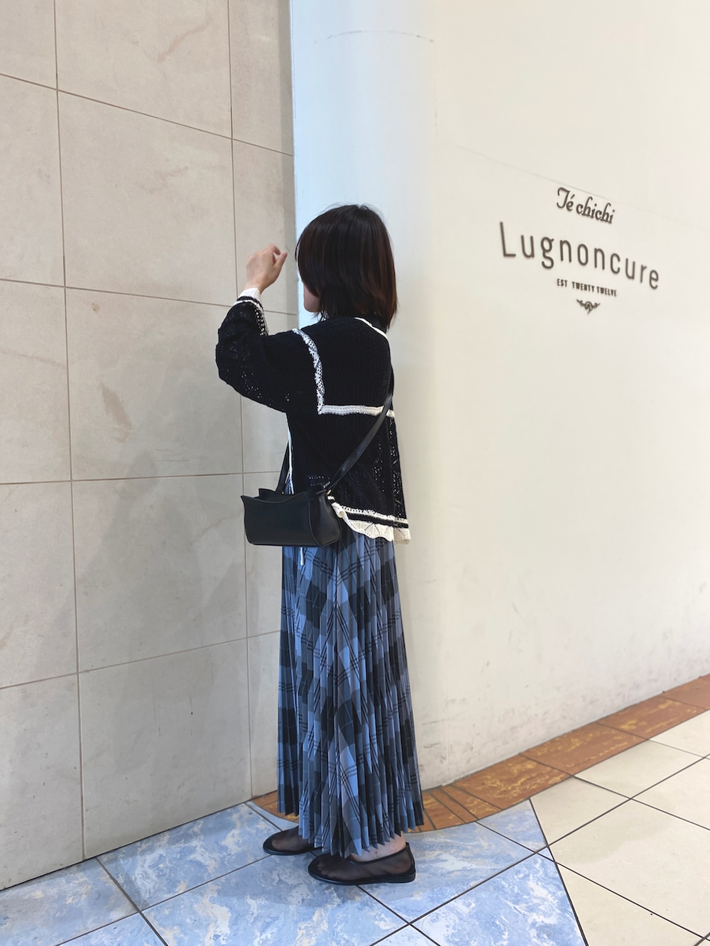 ブラック系のカーディガン/ボレロ、ブラック系のTシャツ/カットソー、ブラック系のハンドバッグを着用したレディースの春コーディネートの2枚目の写真