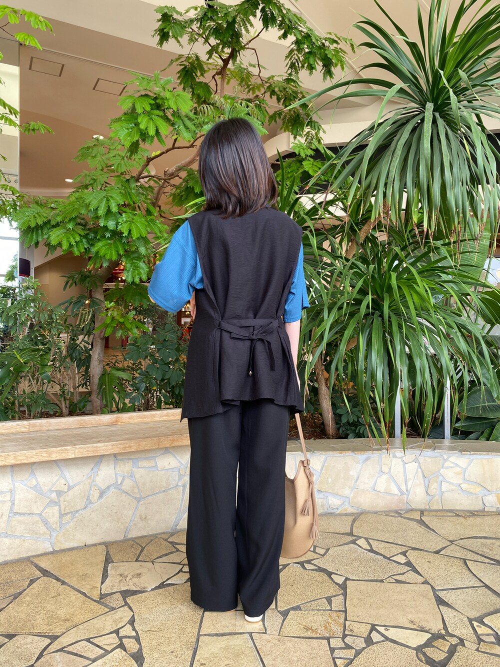 ブルー系のTシャツ/カットソー、ブラック系のその他パンツ、ベージュ系のハンドバッグを着用したレディースの春コーディネートの3枚目の写真