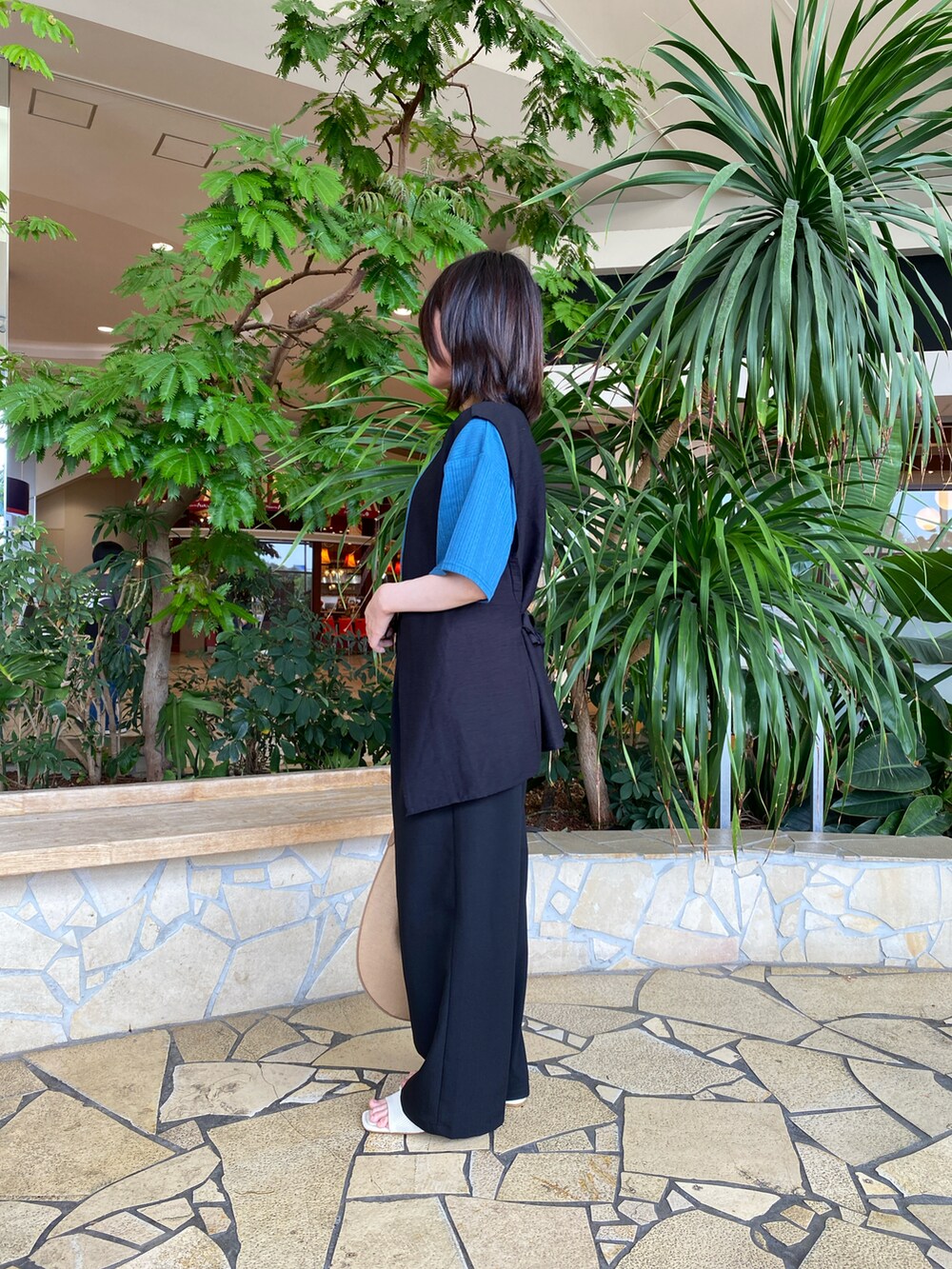 ブルー系のTシャツ/カットソー、ブラック系のその他パンツ、ベージュ系のハンドバッグを着用したレディースの春コーディネートの2枚目の写真